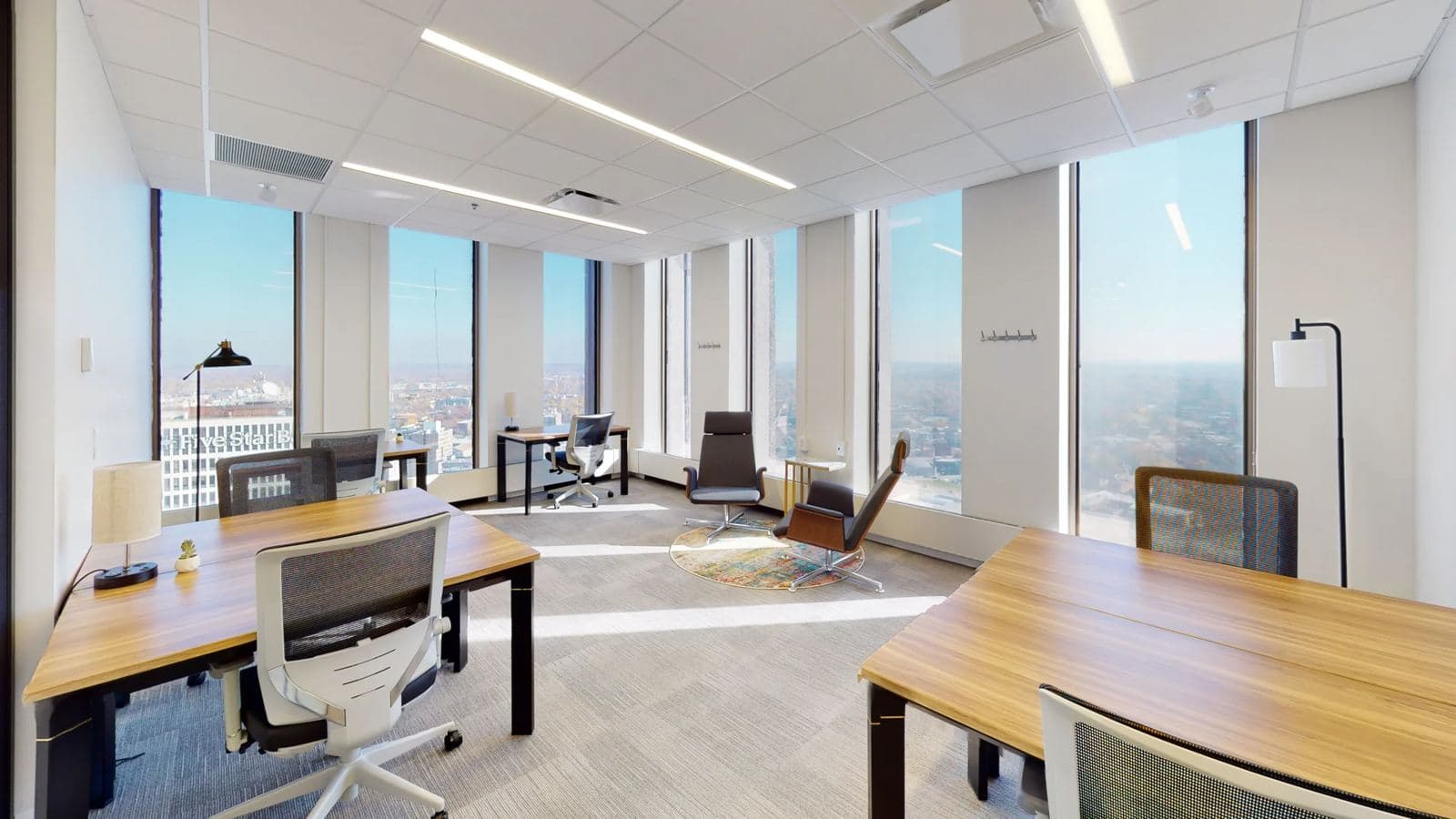 Private office at Serendipity Labs with floor-to-ceiling windows over downtown Rochester